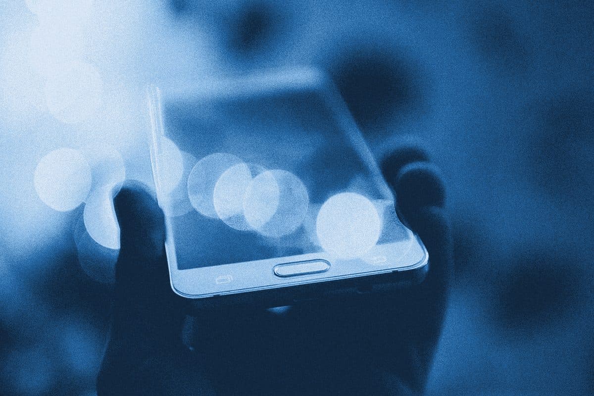 Смартфон у руці на тлі розмитих вогнів